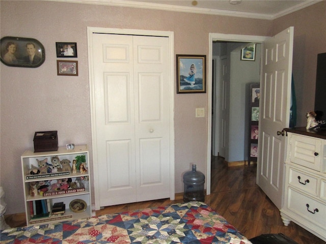 bedroom featuring dark wood-type flooring, ornamental molding, and a closet