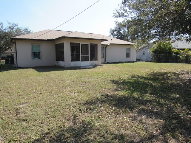 back of house featuring a yard and a sunroom