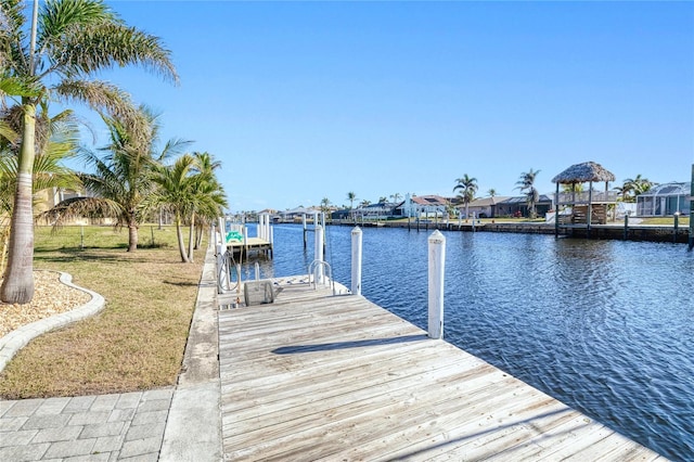 view of dock featuring a lawn and a water view