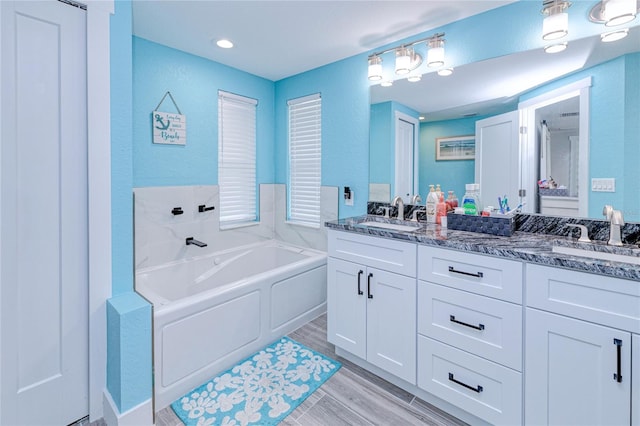 bathroom featuring vanity, hardwood / wood-style floors, and a bathing tub