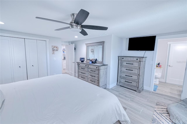 bedroom featuring ceiling fan, ensuite bath, light hardwood / wood-style floors, and a closet