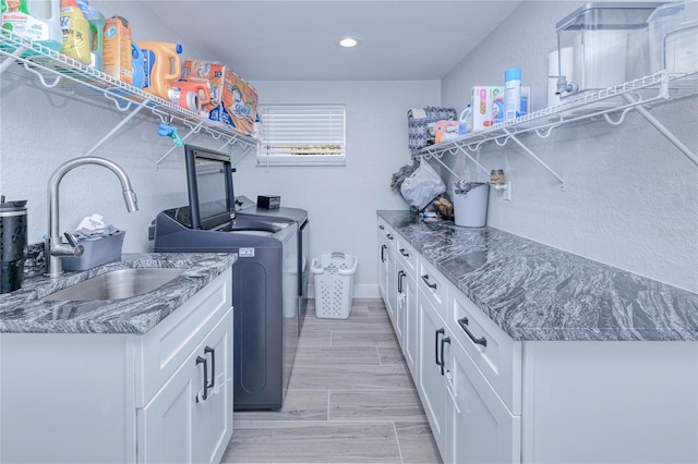 laundry room featuring cabinets, sink, and washer and clothes dryer