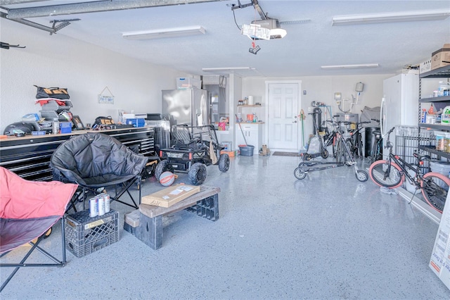 garage with stainless steel refrigerator with ice dispenser and a garage door opener