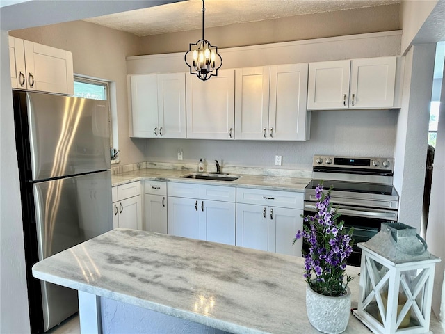 kitchen featuring sink, white cabinetry, pendant lighting, stainless steel appliances, and light stone countertops