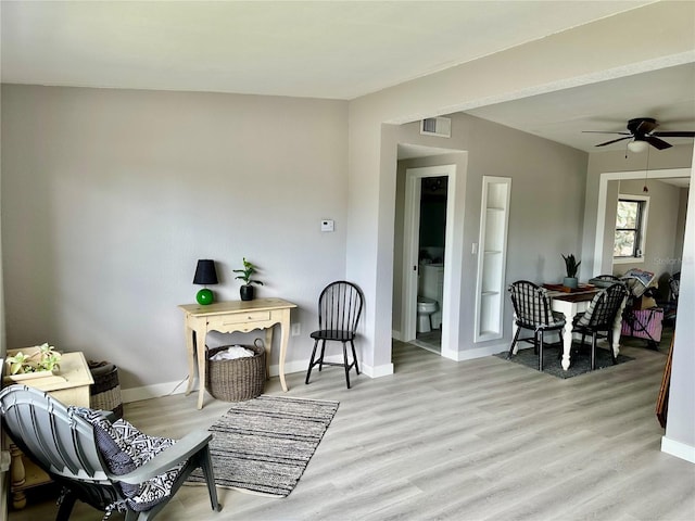 living area featuring light hardwood / wood-style floors and ceiling fan