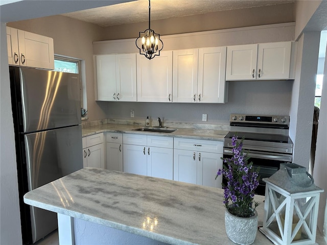 kitchen featuring white cabinetry, sink, decorative light fixtures, and appliances with stainless steel finishes