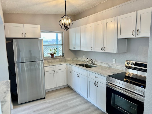 kitchen featuring white cabinetry, sink, pendant lighting, and stainless steel appliances