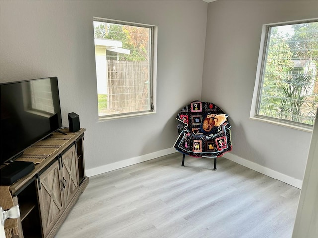 living area with a wealth of natural light and light wood-type flooring