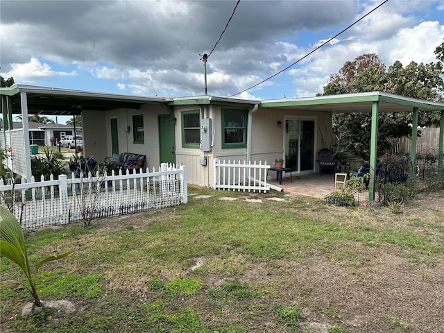 view of front of property featuring a front yard and a carport