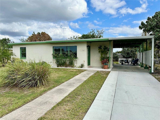 view of front facade featuring a front lawn and a carport