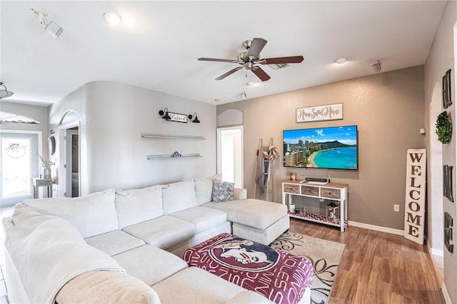 living room featuring ceiling fan and dark hardwood / wood-style flooring