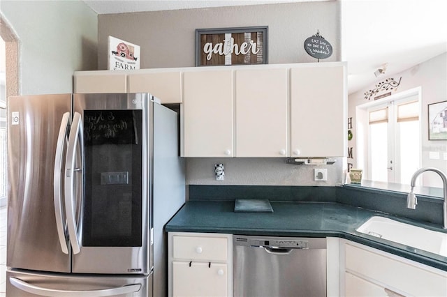 kitchen featuring stainless steel appliances, sink, and white cabinets