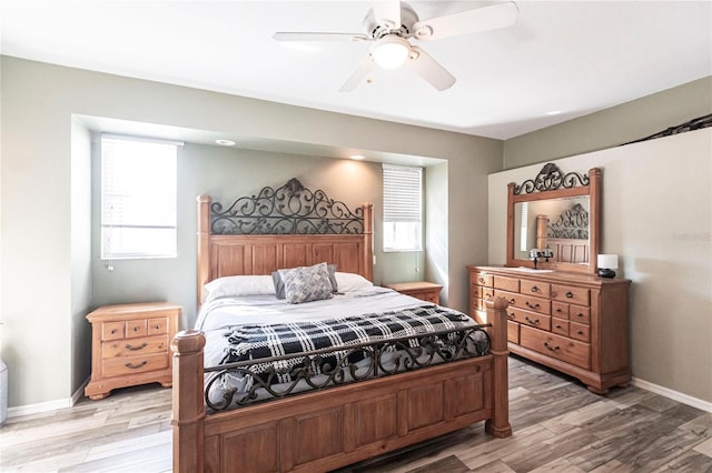 bedroom with multiple windows, hardwood / wood-style flooring, and ceiling fan