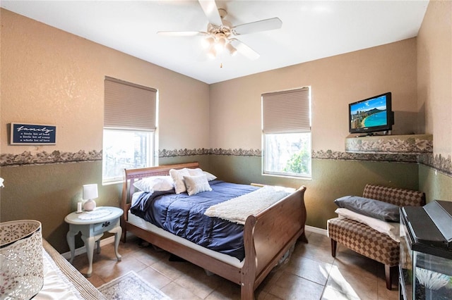 bedroom with multiple windows, light tile patterned floors, and ceiling fan