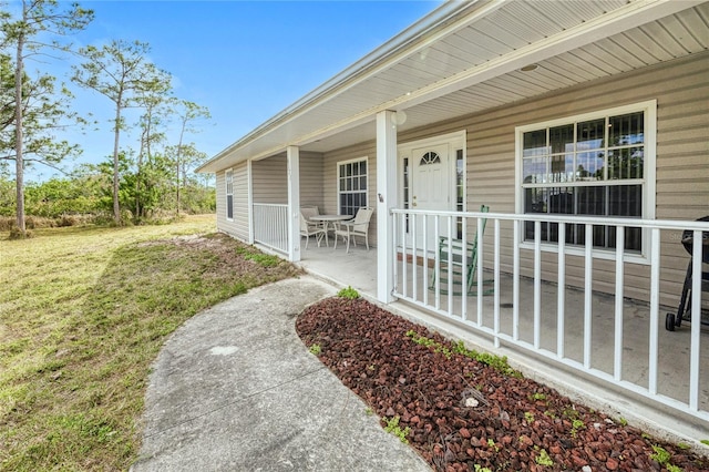 doorway to property featuring a yard and a porch