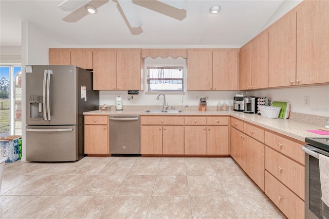 kitchen with light brown cabinetry, sink, light tile patterned floors, appliances with stainless steel finishes, and ceiling fan