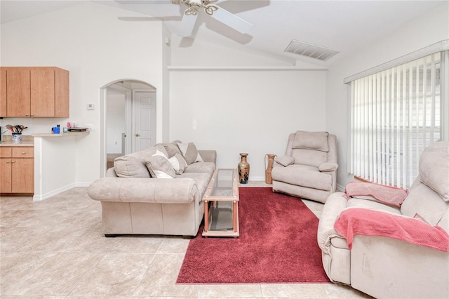 living room with ceiling fan, lofted ceiling, and light tile patterned floors