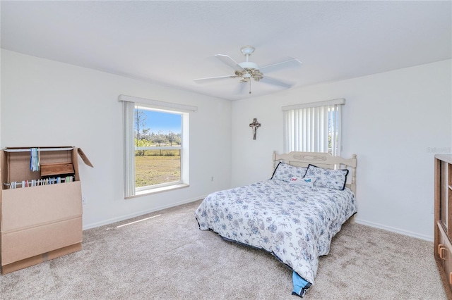 bedroom with multiple windows, light colored carpet, and ceiling fan