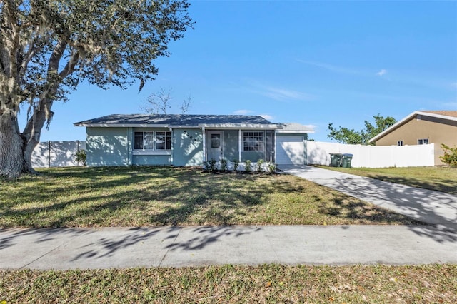 ranch-style house featuring concrete driveway, fence, a front lawn, and stucco siding