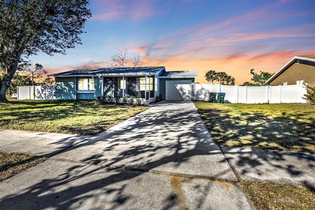 view of front of house with a garage, fence, concrete driveway, and a front yard