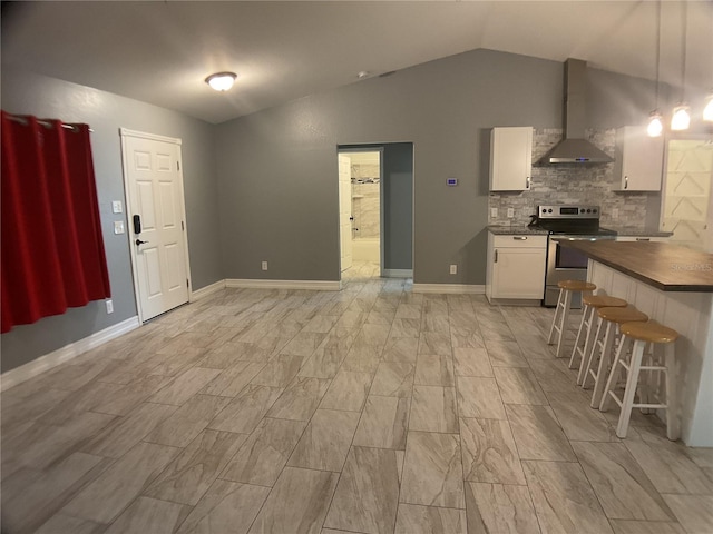 interior space with a breakfast bar area, decorative light fixtures, stainless steel electric range, white cabinets, and wall chimney range hood