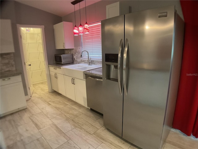 kitchen featuring sink, white cabinetry, tasteful backsplash, decorative light fixtures, and stainless steel appliances