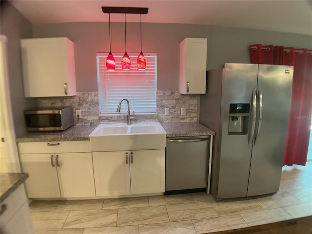 kitchen with sink, white cabinetry, hanging light fixtures, stainless steel appliances, and decorative backsplash