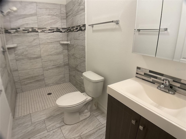 bathroom with vanity, a tile shower, decorative backsplash, and toilet