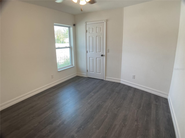 empty room with ceiling fan and dark hardwood / wood-style floors