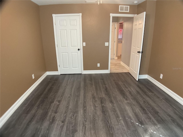 unfurnished bedroom featuring dark hardwood / wood-style floors