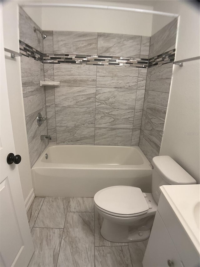 full bathroom featuring tiled shower / bath combo, vanity, and toilet