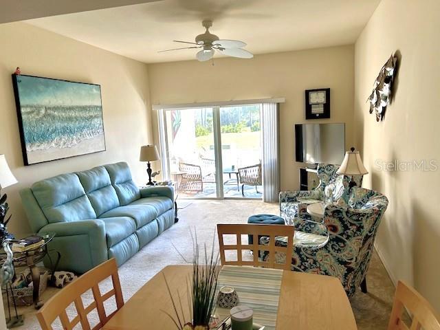 living room featuring light carpet and ceiling fan