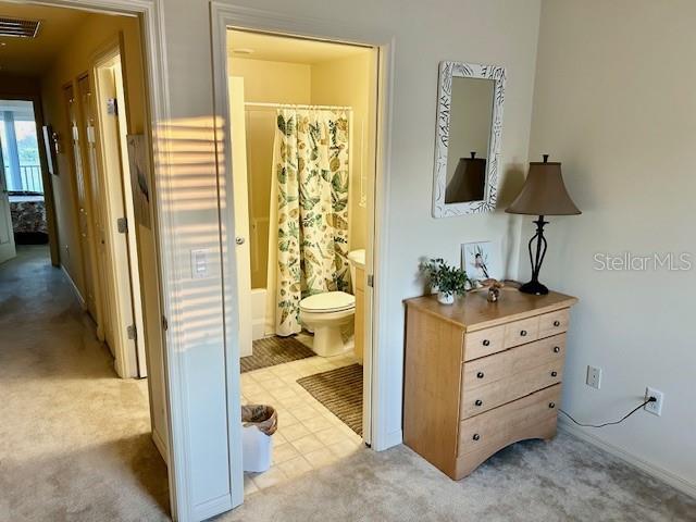 interior space with visible vents, toilet, and shower / bath combo with shower curtain