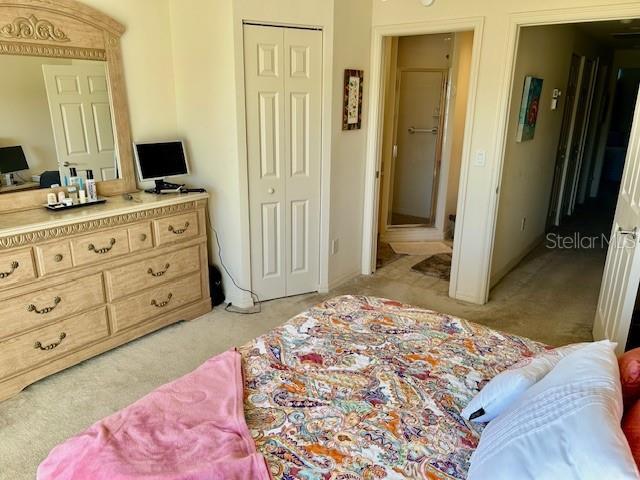 bedroom featuring light carpet and a closet