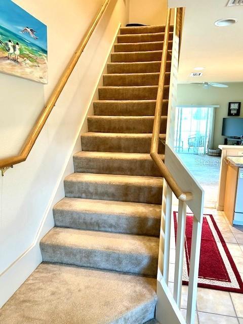 stairs with tile patterned flooring and visible vents