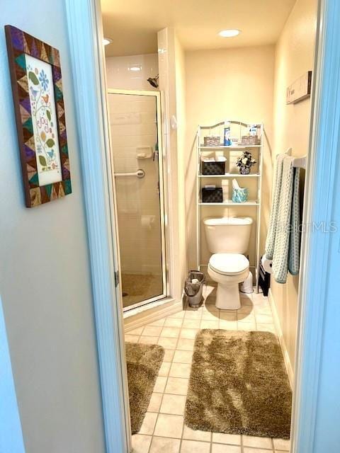 bathroom with tile patterned flooring, an enclosed shower, and toilet