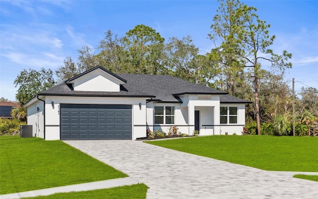 view of front of home featuring cooling unit, a garage, and a front yard