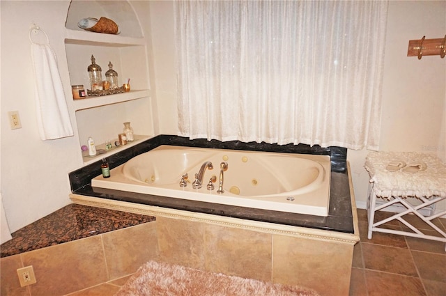 bathroom with tiled tub and tile patterned floors