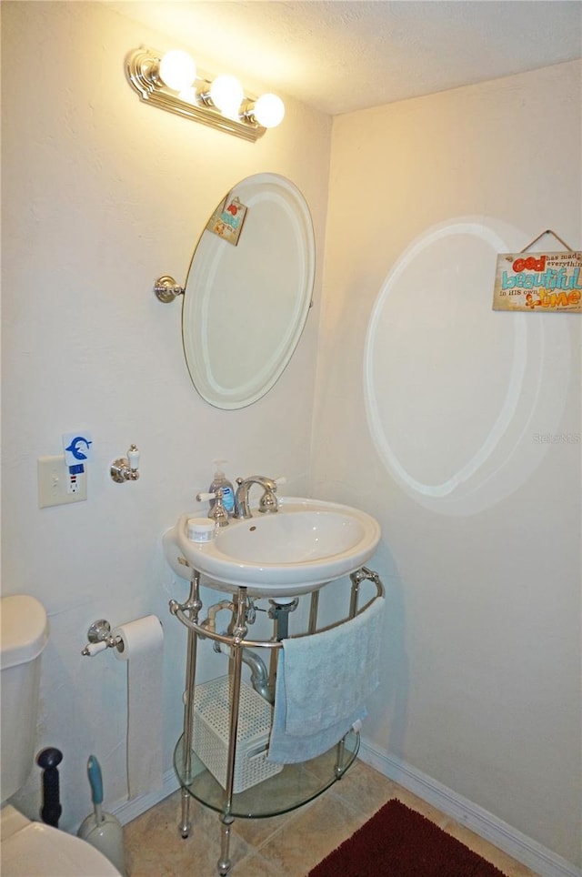 bathroom featuring tile patterned flooring, sink, toilet, and a textured ceiling