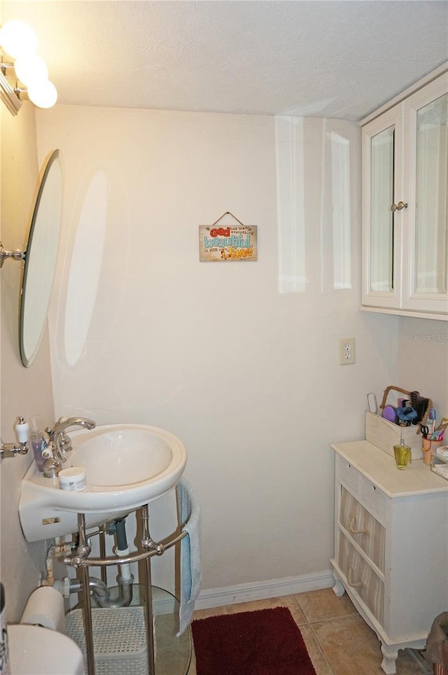 bathroom featuring sink, tile patterned floors, and a textured ceiling