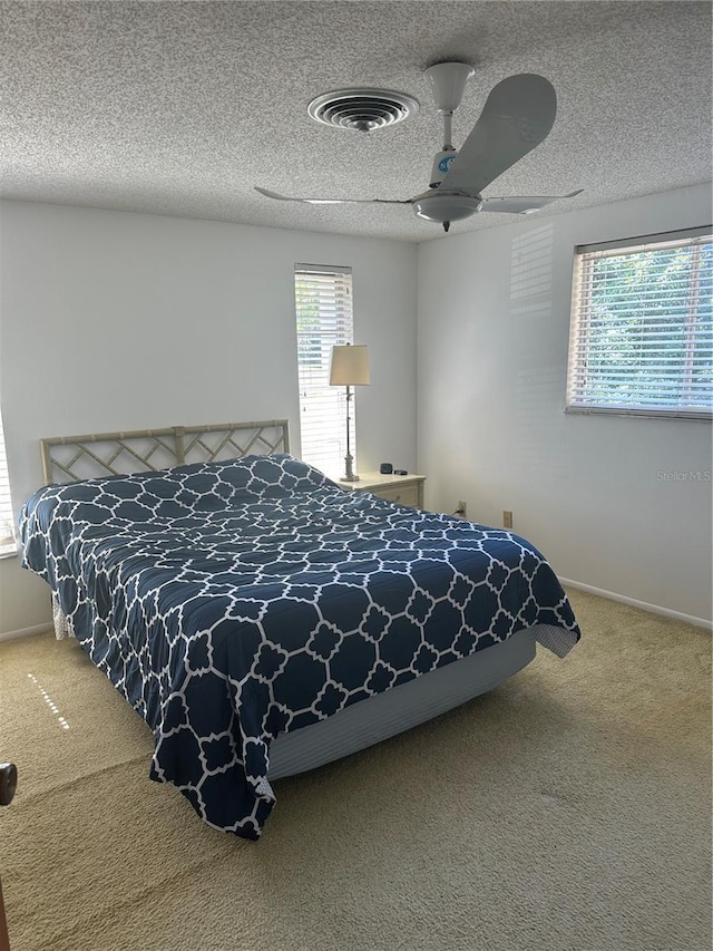 carpeted bedroom with a textured ceiling and ceiling fan