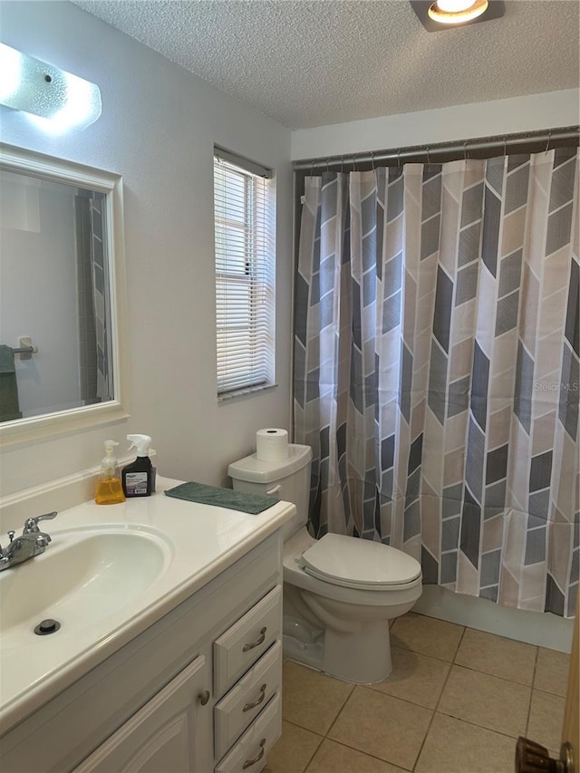 bathroom with vanity, tile patterned floors, a textured ceiling, and toilet