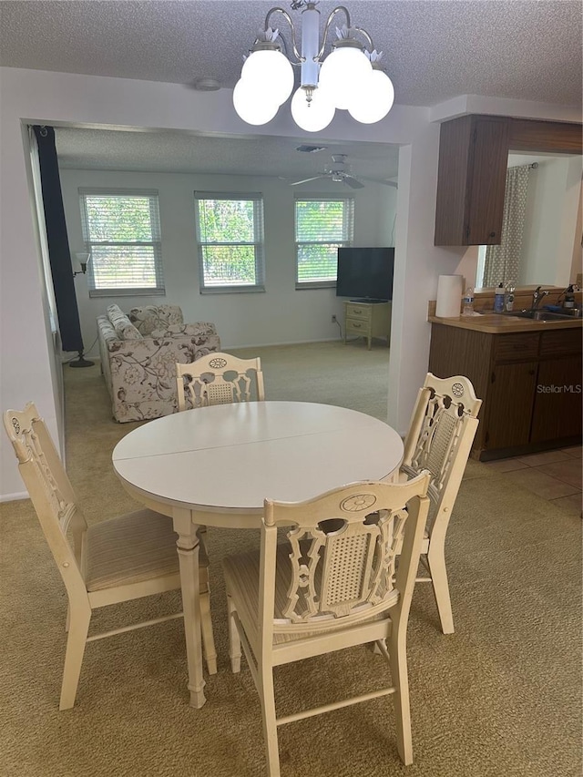 dining area featuring sink, a textured ceiling, and carpet