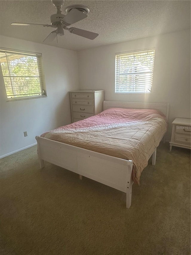 carpeted bedroom with ceiling fan and a textured ceiling