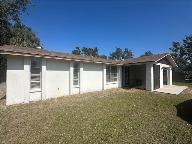 rear view of property featuring a patio and a yard