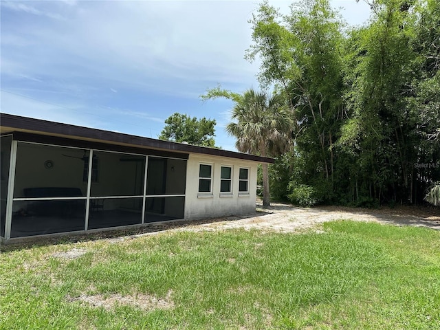 432 Olivia Rd, Venice, FL 34293 - back of house with a lawn, a sunroom, and stucco siding