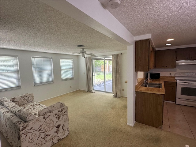 432 Olivia Rd, Venice, FL 34293 - kitchen featuring white electric range oven, a textured ceiling, under cabinet range hood, open floor plan, and light countertops