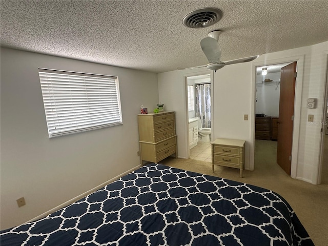 432 Olivia Rd, Venice, FL 34293 - bedroom featuring a walk in closet, connected bathroom, a textured ceiling, and carpet floors