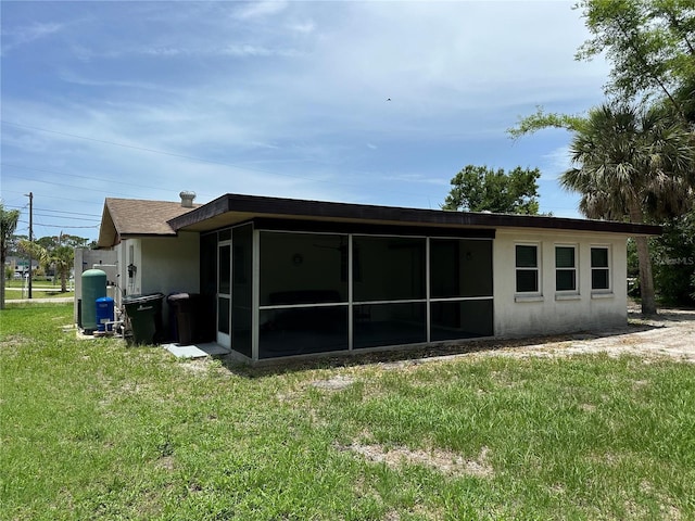 432 Olivia Rd, Venice, FL 34293 - rear view of property featuring a sunroom, a lawn, and stucco siding