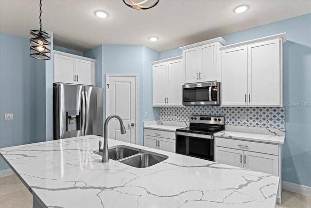 kitchen with white cabinetry, appliances with stainless steel finishes, sink, and pendant lighting